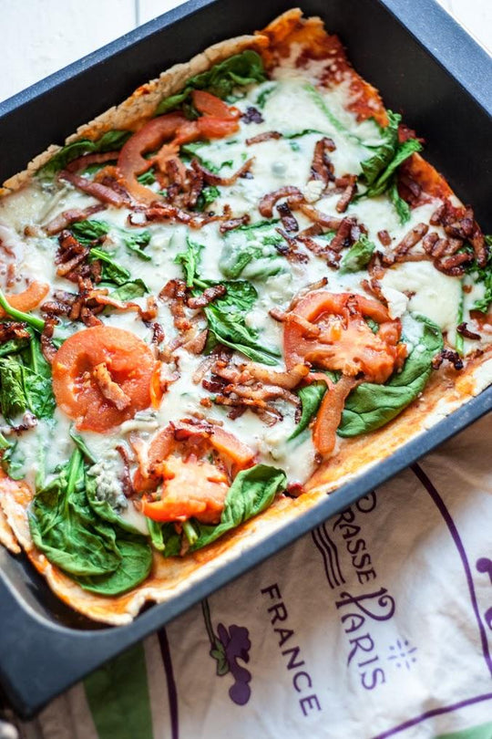 Pizza de espinacas, gorgonzola, tomate y bacon